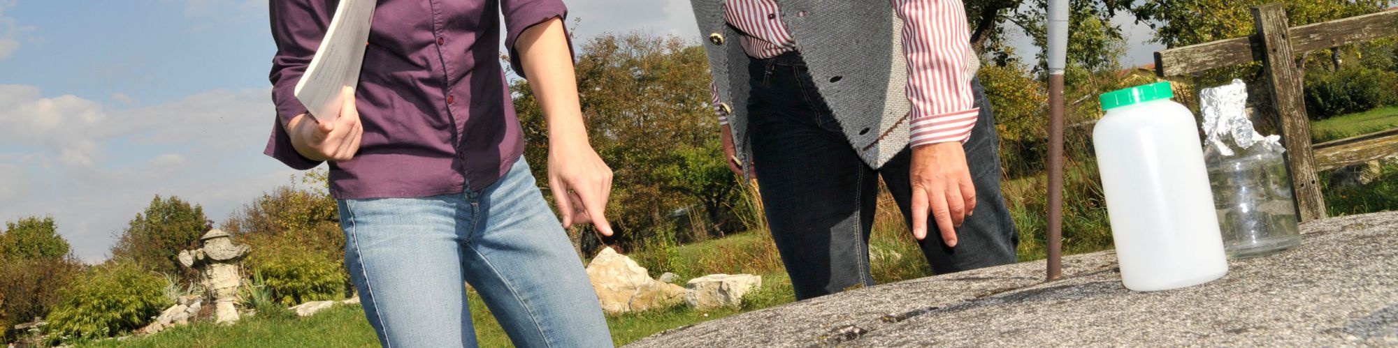 Beraterin mit Kundin vor einem Haubrunnen